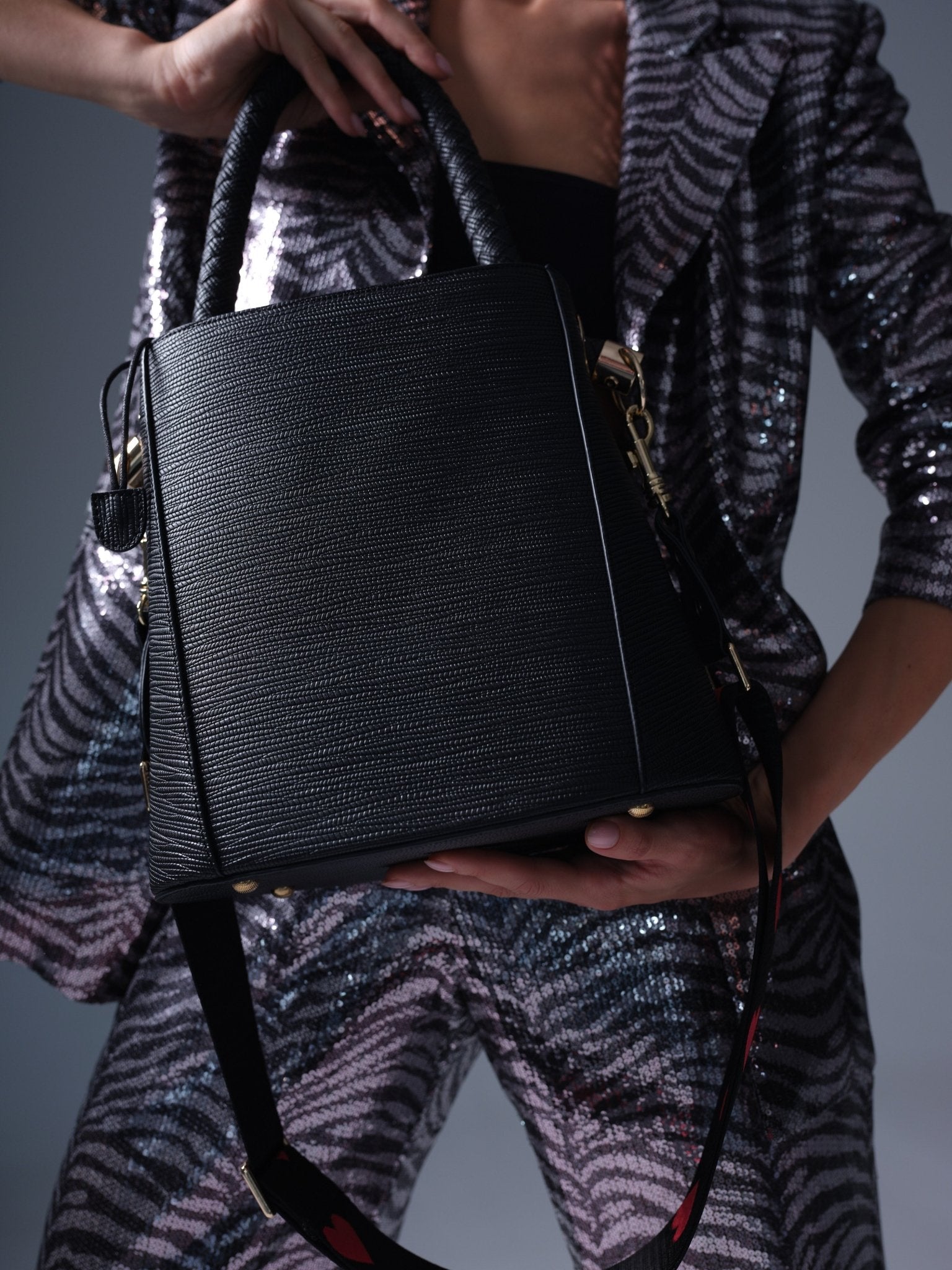 Large black vegan leather bucket bag with braided handle and shoulder strap