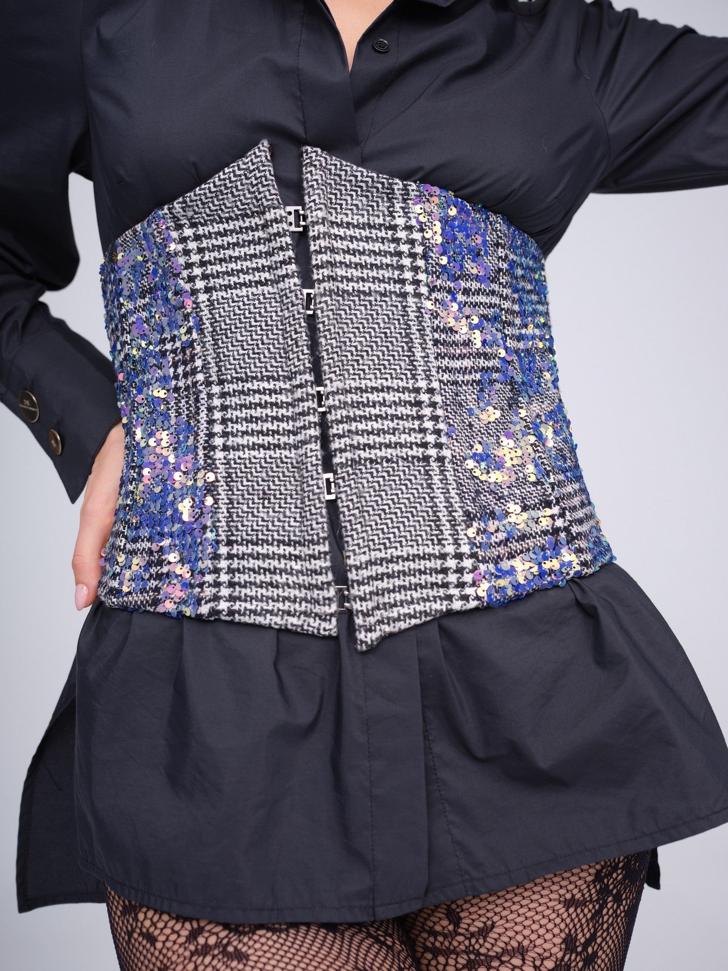 Monochrome check corset with iridescent sequins and front hook closures.