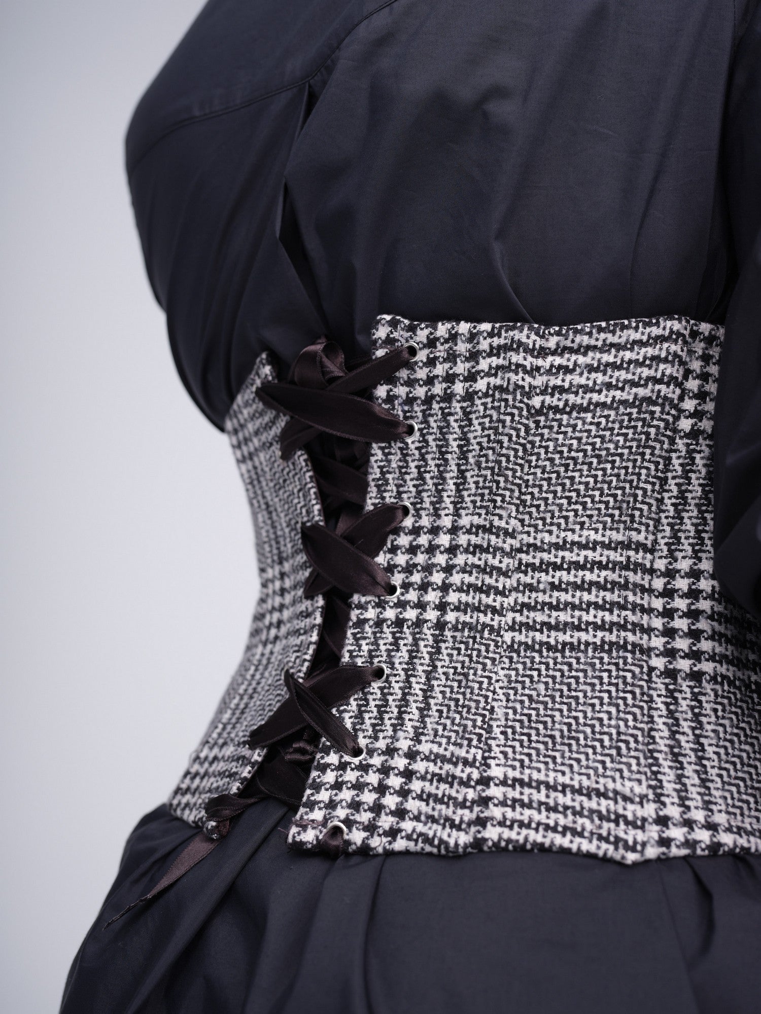 Monochrome check corset with iridescent sequins and front hook closures.