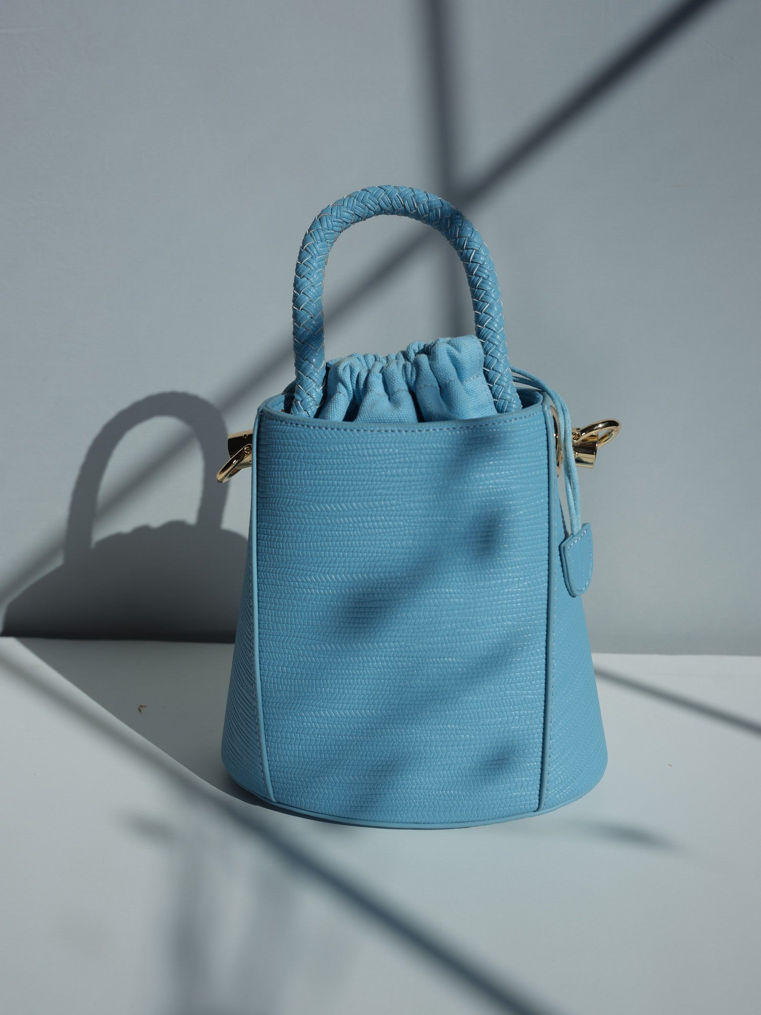 Blue vegan leather bucket bag with braided handle