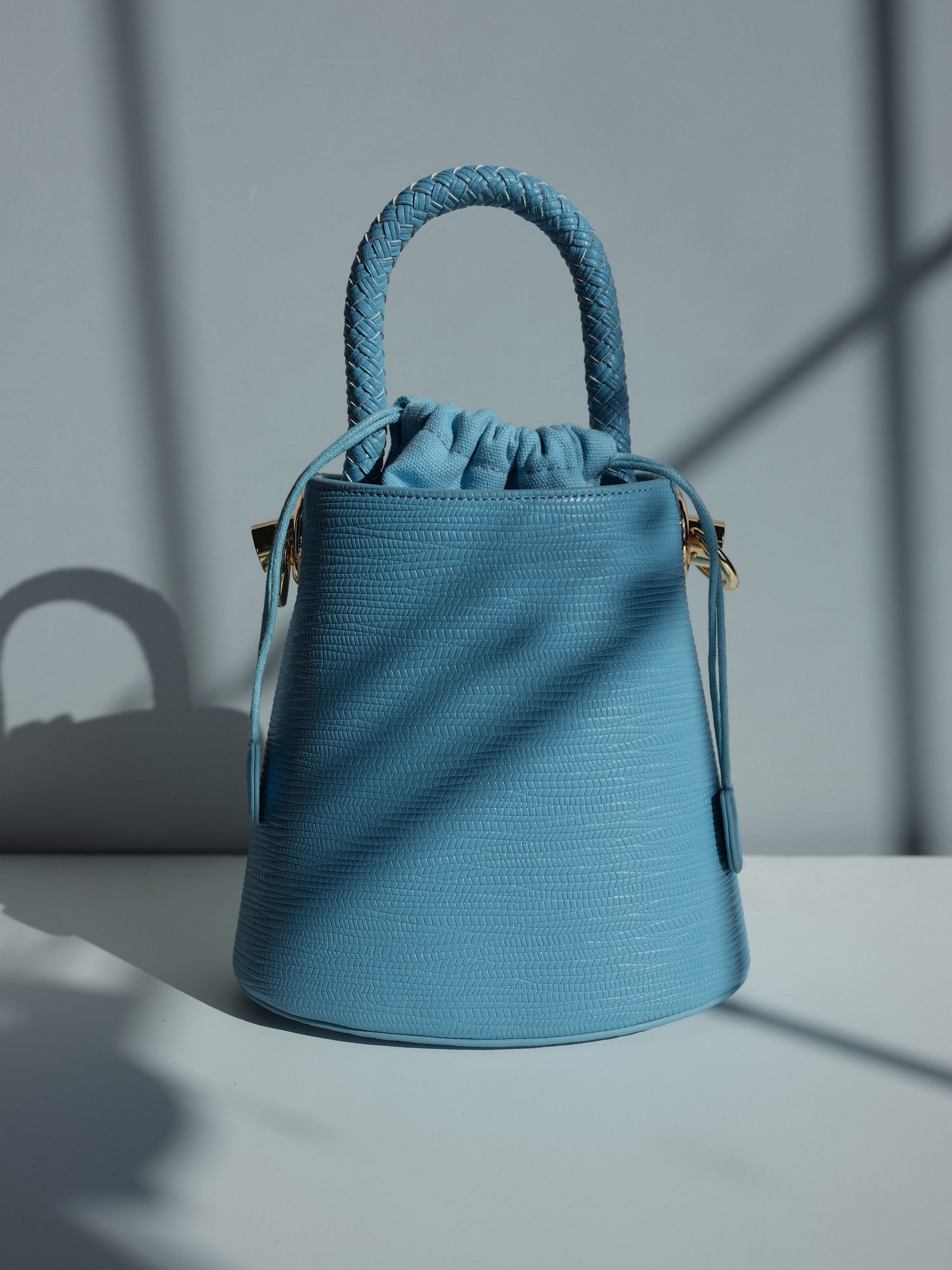 Blue vegan leather bucket bag with braided handle