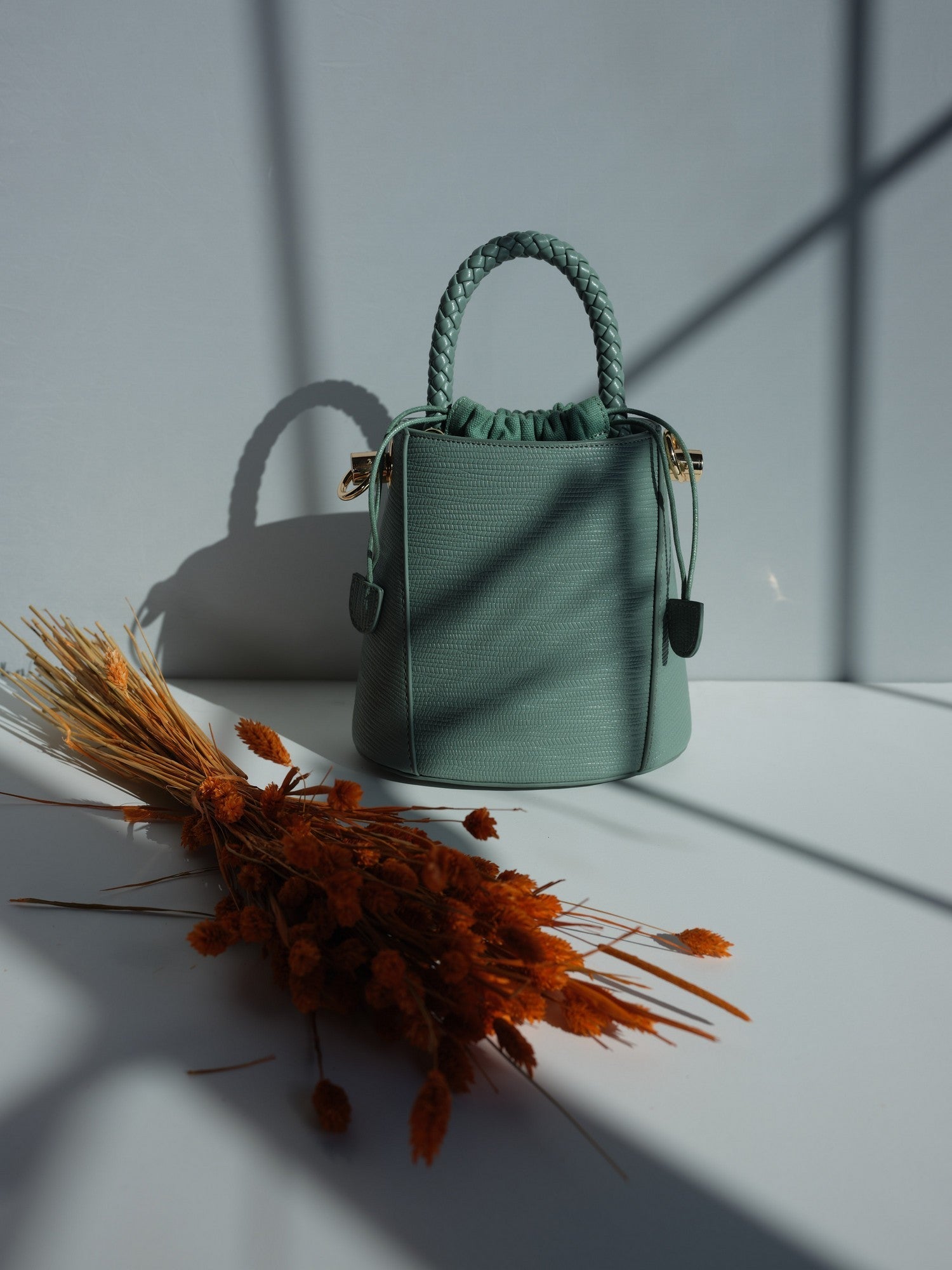 Green vegan leather bucket bag with braided handle