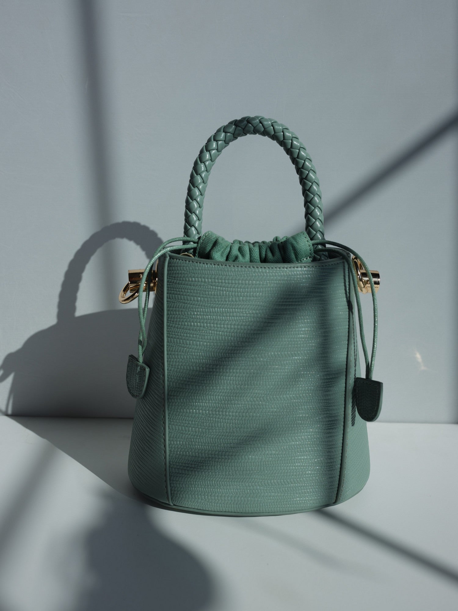 Green vegan leather bucket bag with braided handle